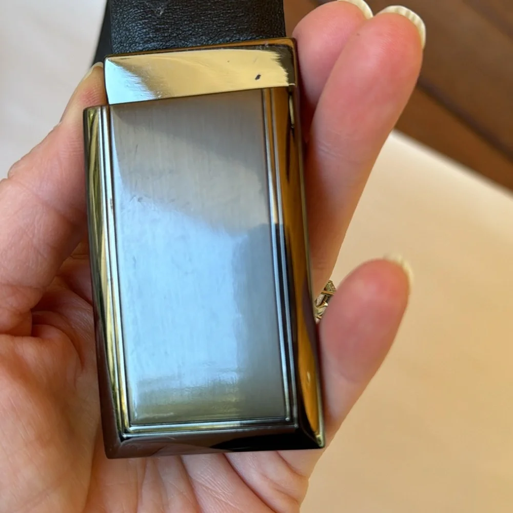 Black leather belt with pewter toned belt buckle. Black. Size 42.